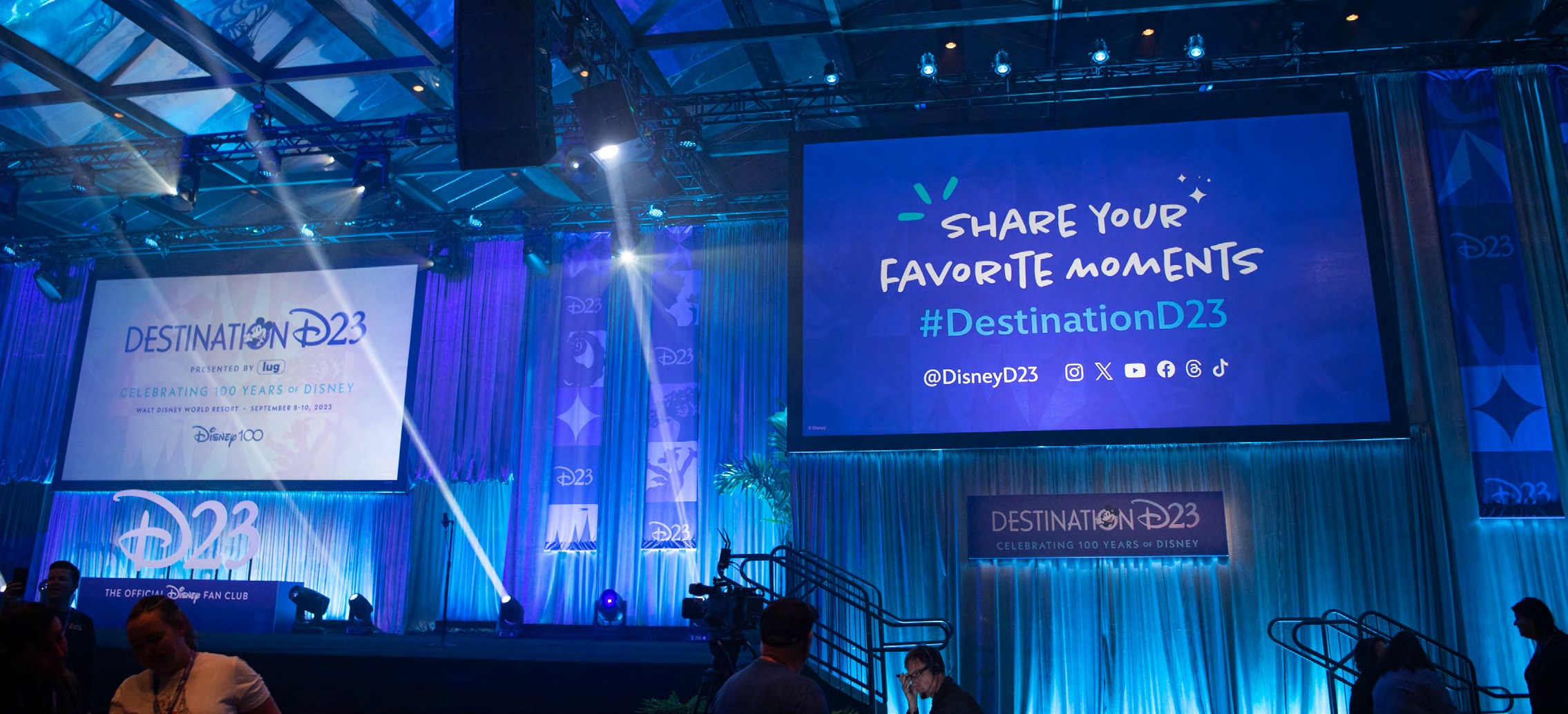 Destination D23 environmental and stage design for the Disney100 celebration, including custom character illustrations in Disney100 purple